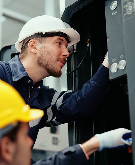 A pair of men in hard hats collaborate on a construction site.
