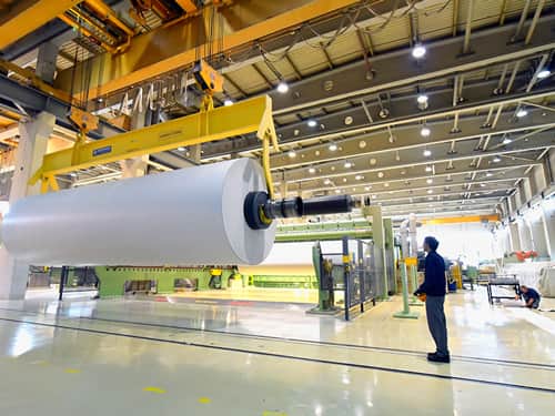 Production of paper in a modern factory paper roll on a crane