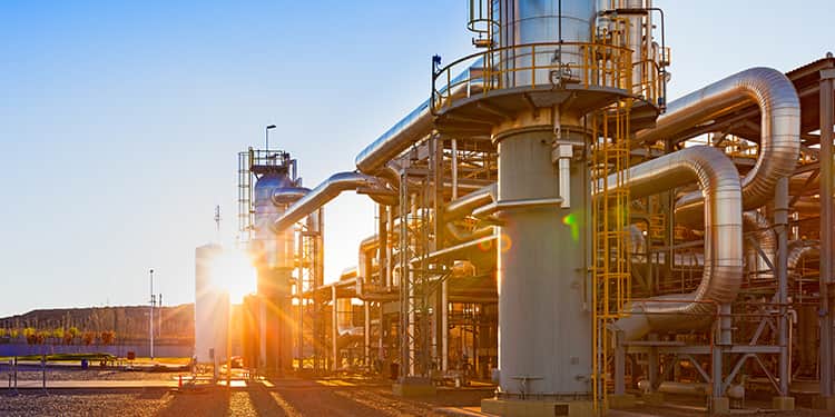 View of a gas refinery plant illuminated at sunset.